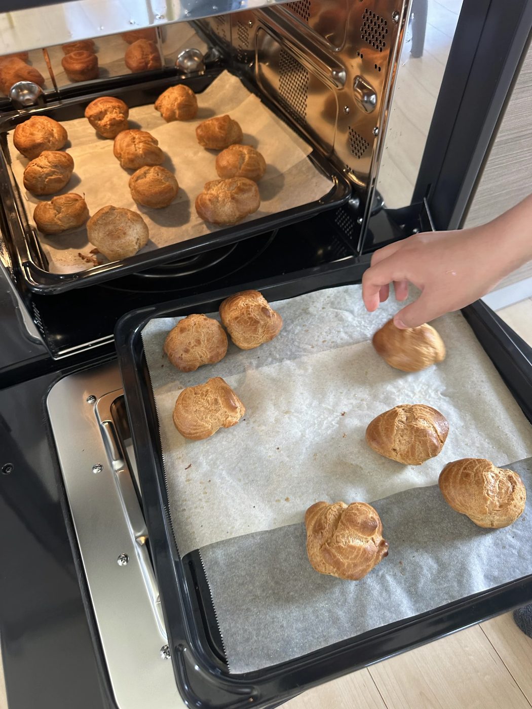 オーブンから焼き上がったシュー生地を取り出すところ
